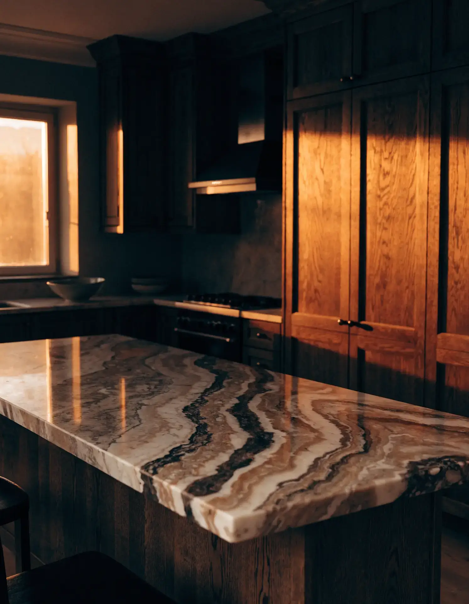 Cocina reformada con isla y encimera de mármol oscuro